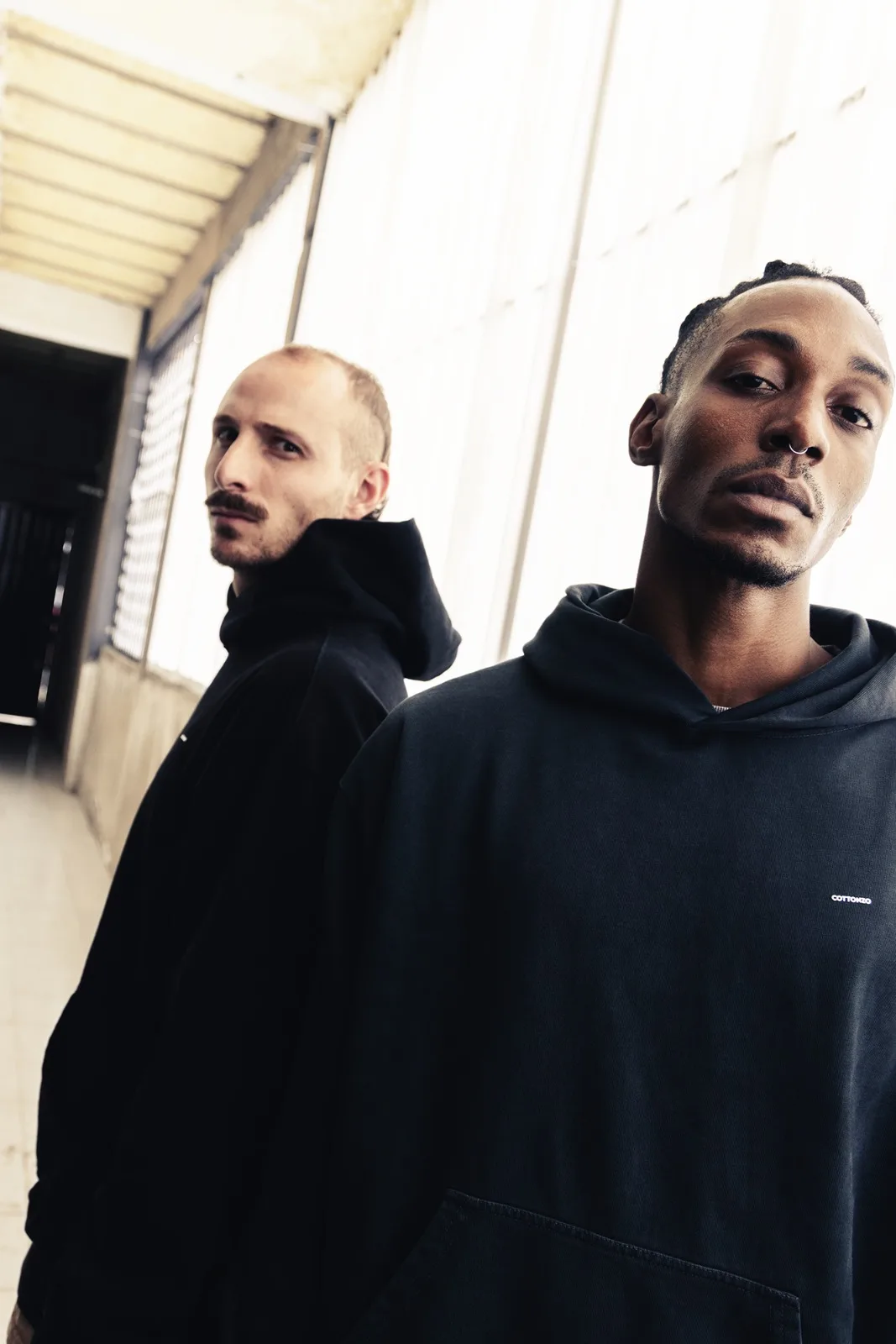 Two men in black, looking up