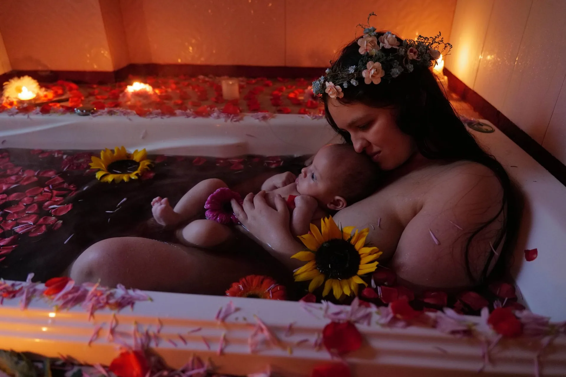 Mother and baby in a bath with sunflowers